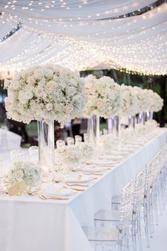 a long table with white flowers and candles on it is set up for an event