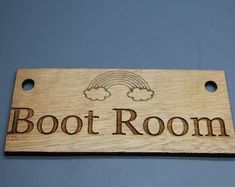 a wooden sign that says boot room on the side of a blue wall with clouds above it