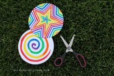 a pair of scissors sitting on top of a grass covered field next to a paper plate