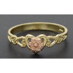 a gold ring with a heart and flower on it