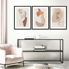 three framed art pieces hang on the wall above a coffee table in a modern living room