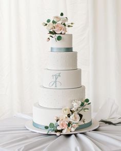 a three tiered wedding cake with flowers on top