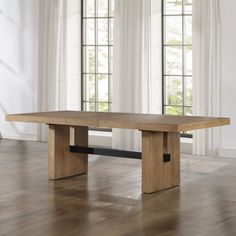 a wooden table sitting in front of two windows