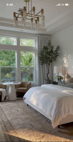 a large bed sitting in a bedroom next to a window with lots of light on it