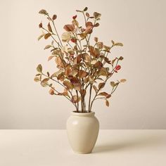 a white vase filled with flowers on top of a table