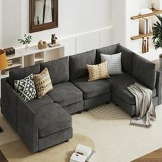 a living room filled with lots of furniture and pillows on top of the couches