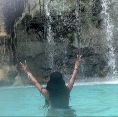 a woman standing in the water with her arms up