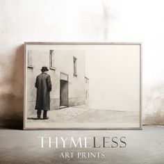 a black and white photo of a man standing in front of a door with the words thyness art prints on it