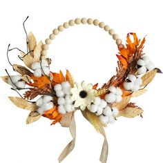 a wreath made out of cotton, leaves and other things on a white background with a wooden bead