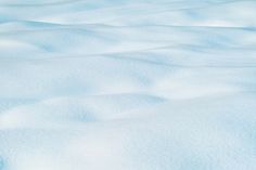 snow covered ground with blue sky and white clouds in the backgrouds, taken from above