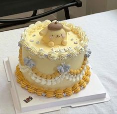 a baby shower cake with a teddy bear on top