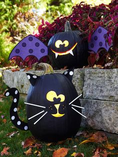 two pumpkins decorated to look like cats and bats