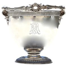 an ornate silver vase with monogram on it