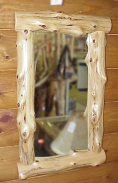 a mirror hanging on the side of a wooden wall