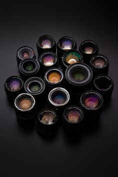 a group of different colored lenses sitting on top of a black table next to each other