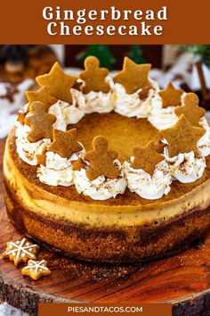 a cheesecake topped with gingerbread cookies on top of a wooden cutting board next to a christmas tree