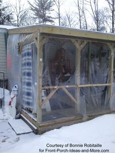 an outdoor covered in snow next to a fence and building with plastic coverings on it