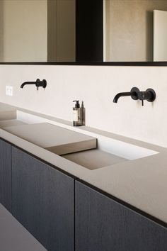 a bathroom with two sinks and mirrors above it