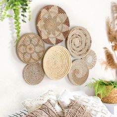 woven baskets are hanging on the wall above a bed