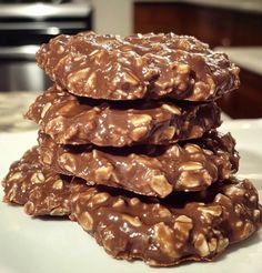 three chocolate cookies stacked on top of each other in front of a kitchen countertop