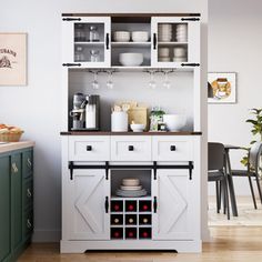 a kitchen with white cupboards and dishes on the top shelf, in front of a dining room table