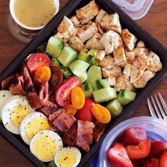 a salad with eggs, tomatoes, cucumbers and bacon on it next to a cup of coffee