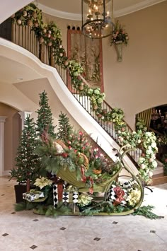 a staircase decorated with flowers and greenery next to a christmas tree in a house