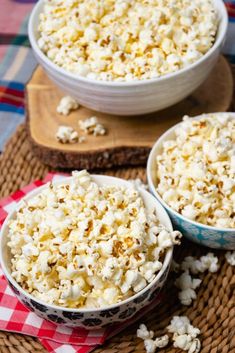 two bowls filled with popcorn sitting on top of a table