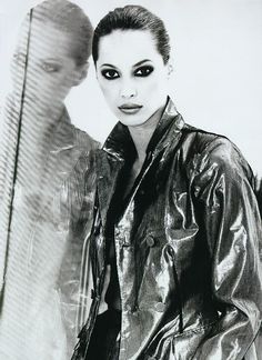 a black and white photo of a woman in a leather jacket