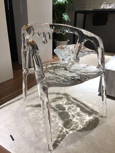 a glass chair sitting on top of a white floor