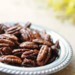 a plate full of pecans sitting on a table