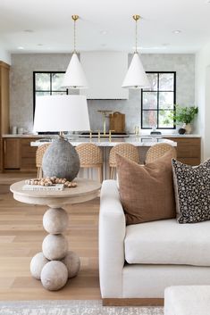 a living room filled with furniture next to a kitchen