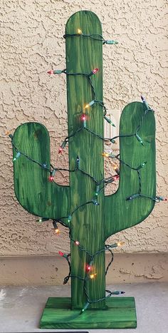 a wooden cactus with christmas lights on it