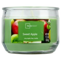 a glass jar filled with lots of green apples