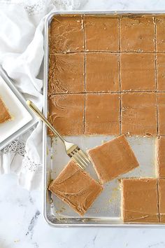 a pan filled with peanut butter squares next to a fork