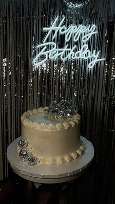 a birthday cake sitting on top of a table next to a sign that says happy birthday