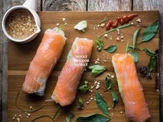 three raw salmons on a cutting board with spices and seasoning next to them