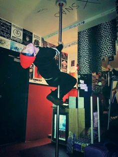 a skateboarder is doing tricks on a pole in the middle of a room