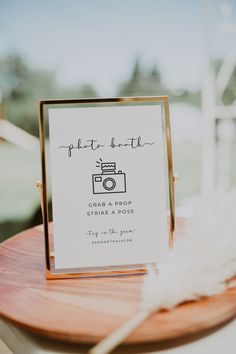 the welcome sign is placed on top of a wooden table with feathers in front of it