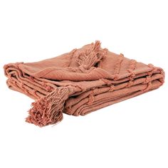 two blankets folded on top of each other with fringed edges and tassels