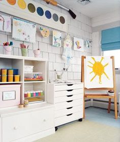 a child's playroom with toys and art on the walls