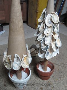 two vases with shells on them sitting next to each other