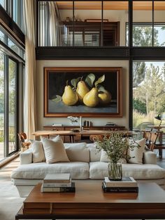 a living room filled with lots of furniture next to large windows and a painting on the wall