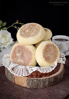 some biscuits are stacked on top of each other in a basket next to a cup of coffee