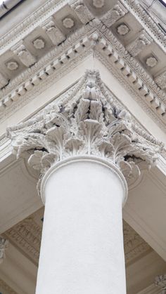 an ornate column stands in front of a white building