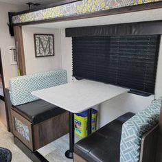 the inside of a recreational vehicle with two couches and a table in front of it