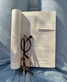 an open book with glasses resting on it