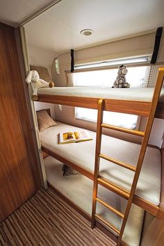 a bunk bed in the corner of a room with wooden flooring and ladders