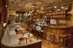 the inside of a restaurant with lots of tables and stools in front of it