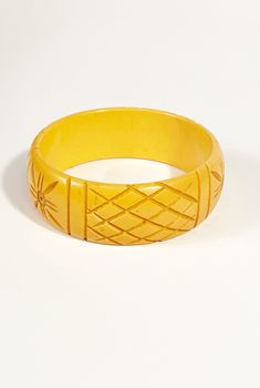 "1940s butterscotch yellow Bakelite bracelet with a carved design and lovely patina. Exterior Circumference: 9.5\" Width: 1\" Interior Diameter: 2.5\" Label: None. Condition: Excellent vintage condition. All vintage is sold in \"as-is\" condition. We do our best to inspect, correct, and list important flaws. All measurements are made with the garment laying flat. Length is measured from shoulder to hem unless otherwise noted. Questions? Send us a message! Please review our policies here: http:// Vintage Amber Bangle Bracelet, Vintage Yellow Round Bracelets, Vintage Bakelite Bangle Jewelry, Vintage Bakelite Bangle, Vintage Carved Orange Jewelry, Vintage Carved Amber Jewelry, Vintage Amber Carved Jewelry, Vintage Orange Carved Jewelry, Orange Carved Vintage Jewelry